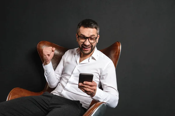 Izgatott üzletember ül mobiltelefon használata. — Stock Fotó
