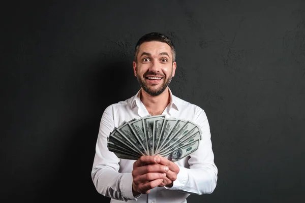 Cheerful businessman holding money. — Stock Photo, Image