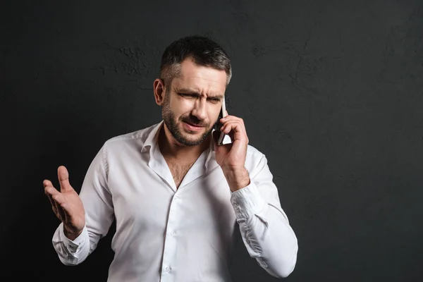 Missnöjd affärsmannen pratar via mobiltelefon. — Stockfoto