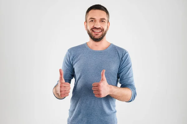 Sorrindo jovem mostrando polegares para cima . — Fotografia de Stock