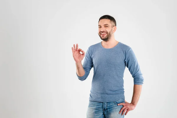 Lächelnder junger Mann zeigt okay Geste. — Stockfoto