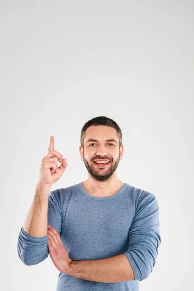 Schöner lächelnder junger Mann zeigt. — Stockfoto