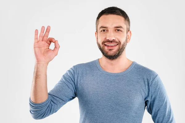 Lächelnder junger Mann zeigt okay Geste. — Stockfoto