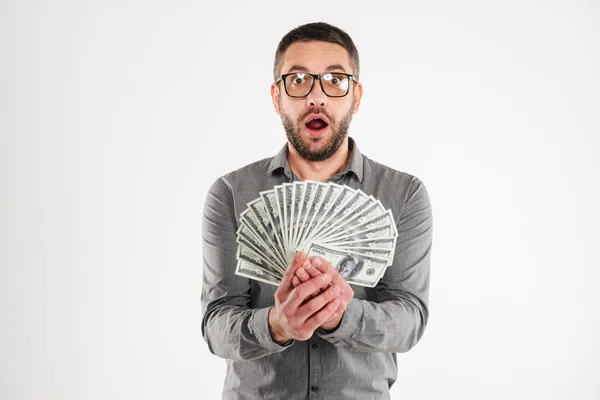 Šokovaný podnikatel drží peníze. — Stock fotografie