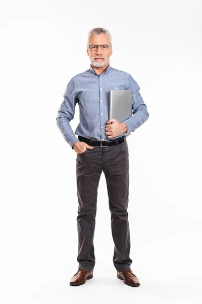 Confident mature man holding laptop and looking camera seriously — Stock Photo, Image