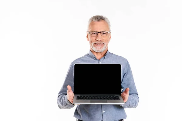 Old smiling man showing laptop with blank screen isolated — Stock Photo, Image