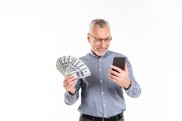 Mature man holding dollars and using smartphone isolated — Stock Photo, Image