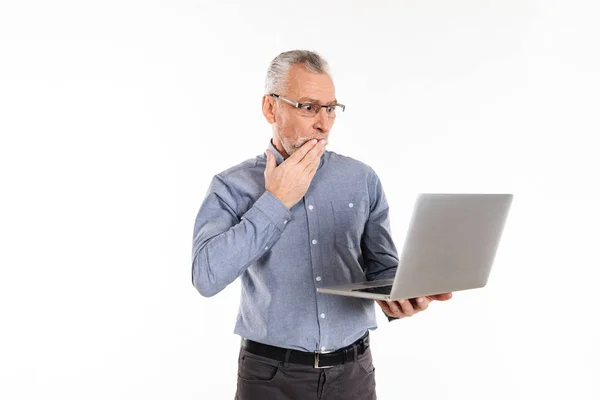 Homem chocado usando computador portátil e posando isolado — Fotografia de Stock