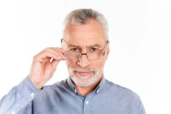 Homem sério segurando seus óculos e olhando câmera isolada — Fotografia de Stock