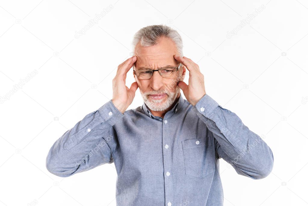 Confused old man have a headache and holding his head