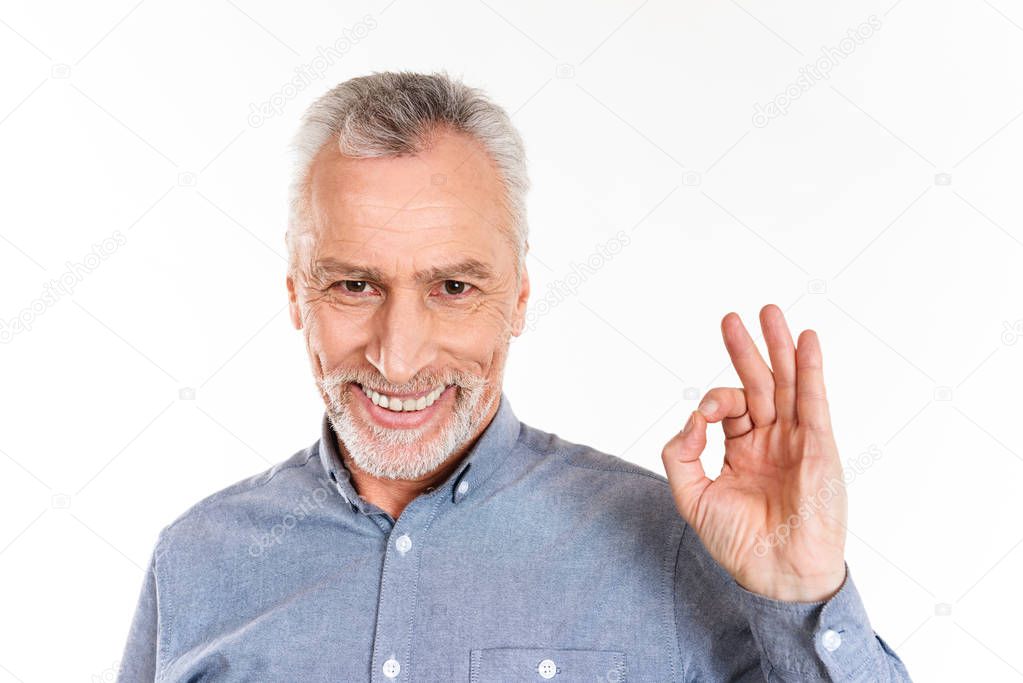 Happy man showing ok gesture and smiling isolated over white