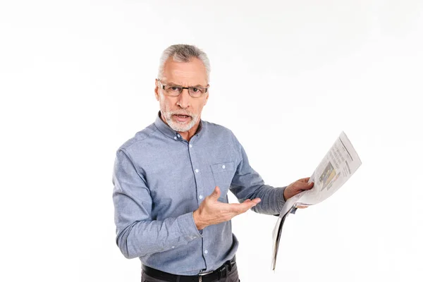 Homem descontente olhando para câmera com raiva e apontando para jornal isolado — Fotografia de Stock