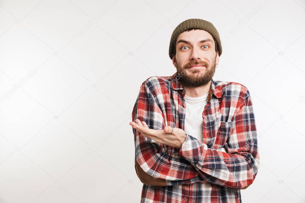 Portrait of a smiling bearded man in plaid shirt pointing away