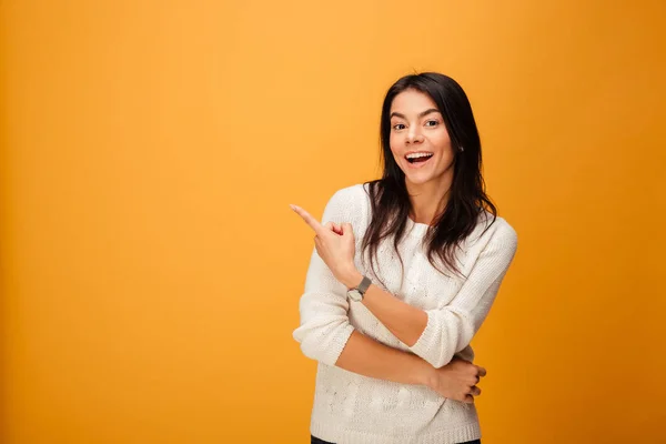 Porträt einer glücklichen jungen Frau, die mit dem Finger wegzeigt — Stockfoto