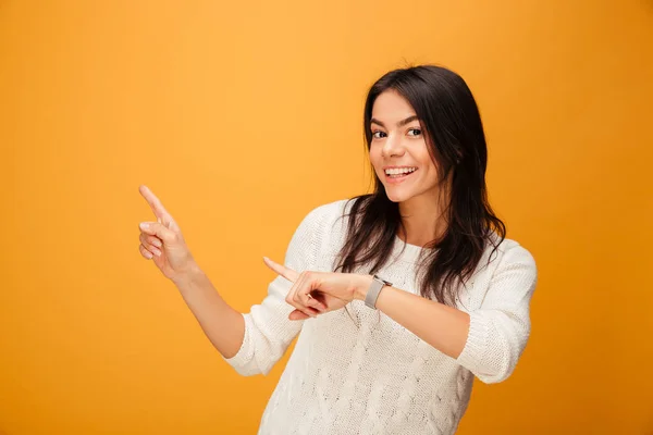 Retrato de uma jovem sorridente apontando os dedos para longe — Fotografia de Stock