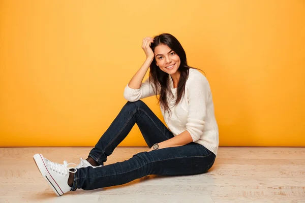 Portrét usměvavé mladé ženy sedí na podlaze — Stock fotografie