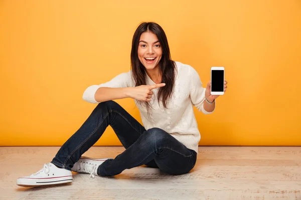 Portret van een enthousiast jonge vrouw zitten op een verdieping — Stockfoto