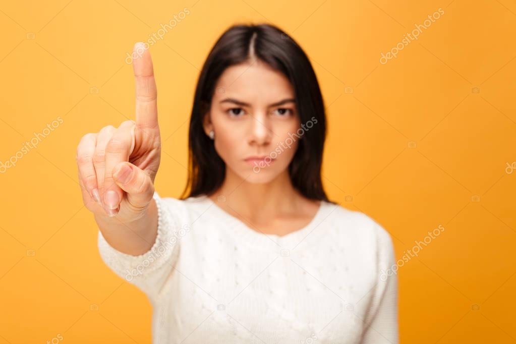 Portrait of a serious young woman showing stop gesture