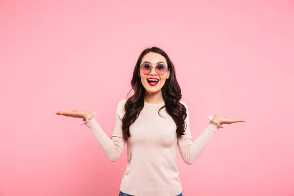Mujer alegre usando gafas de sol redondas sonriendo y haciendo publicidad — Foto de Stock