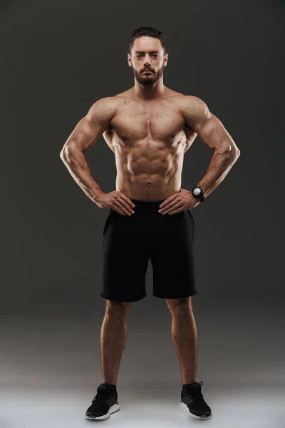 Full längd porträtt av en motiverad muskulös man poserar — Stockfoto