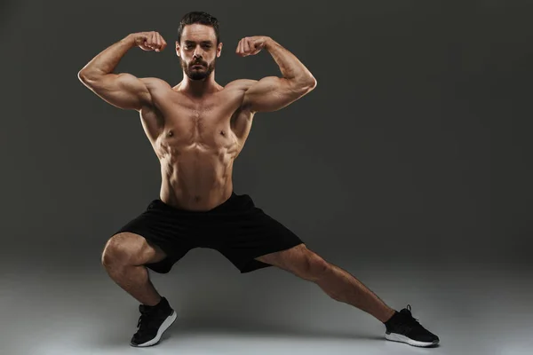 Retrato de un musculoso musculoso en forma flexionando bíceps — Foto de Stock