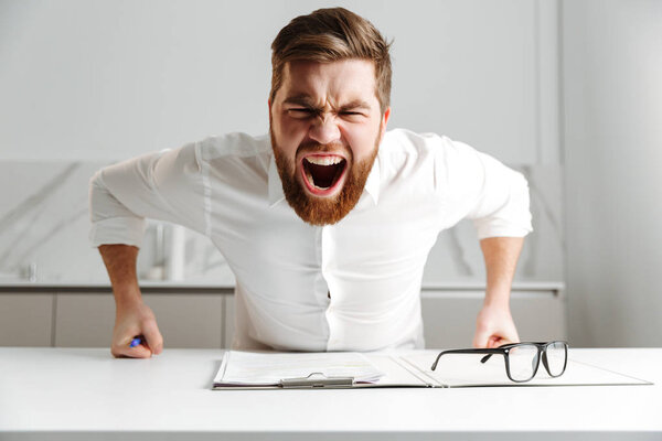 Portrait of a furious young businessman dressed in suit shouting