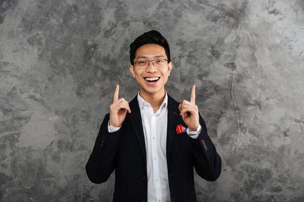 Portrait of a happy young asian man dressed in suit — Stock Photo, Image