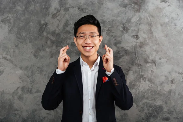 Portrait of a cheerful young asian man dressed in suit — Stock Photo, Image