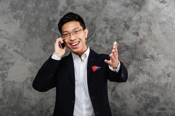 Porträtt av en nöjd ung asiatisk man klädd i kostym — Stockfoto