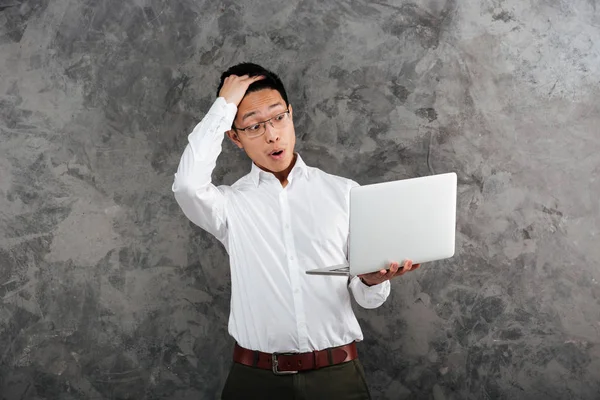 Portret van een geschokt jonge Aziatische man gekleed in t-shirt — Stockfoto