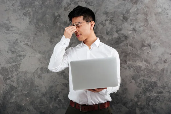 Portrait of a tired young asian man dressed in shirt — Stock Photo, Image