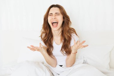 Yatağın üstüne oturan genç bir kadın portresi