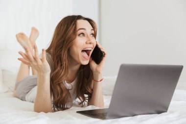 Cep telefonu üzerinde konuşurken neşeli bir genç kadın portresi