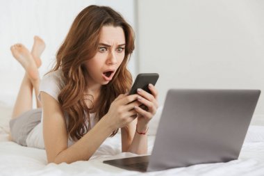 Cep telefonu tutan sürpriz bir genç kadın portresi