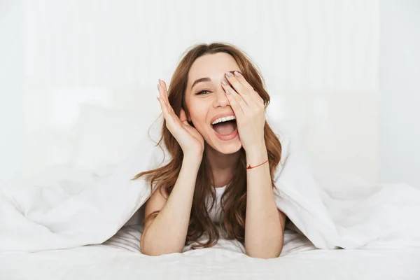 Porträtt av en nöjd ung kvinna i sängen — Stockfoto