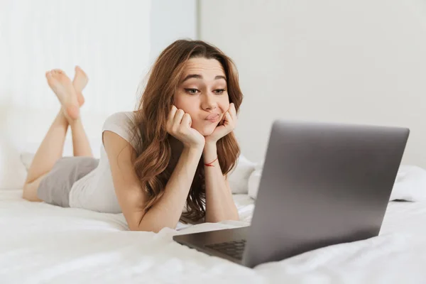 Portrait of a bored young woman lying in bed at home — Stock Photo, Image
