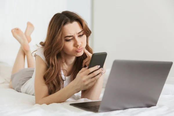 Portrait of an upset young woman holding mobile phone — Stock Photo, Image