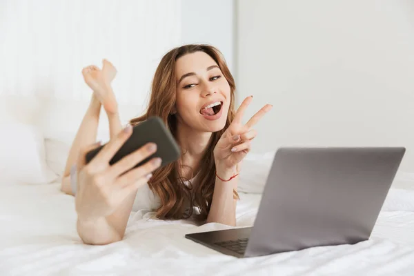 Portrait of a happy young woman taking selfie — Stock Photo, Image