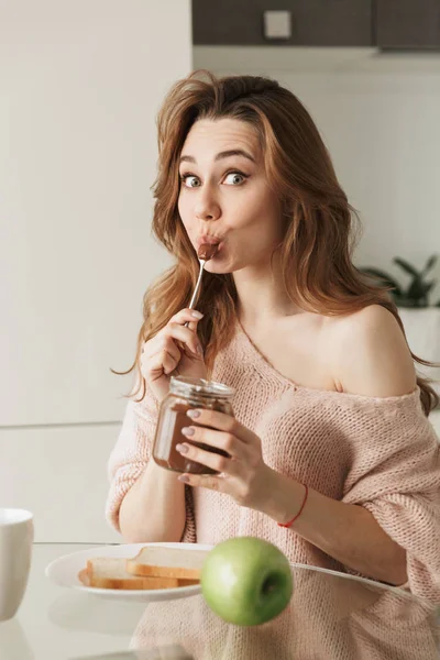 Retrato de una joven satisfecha desayunando sabroso —  Fotos de Stock