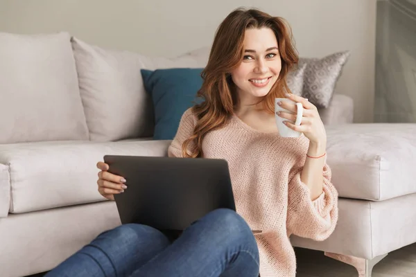 Porträt einer lächelnden jungen Frau, die am Laptop arbeitet — Stockfoto