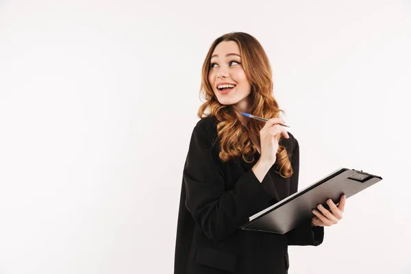 Vrolijke elegante dame in jas klembord houden en kijken weg — Stockfoto