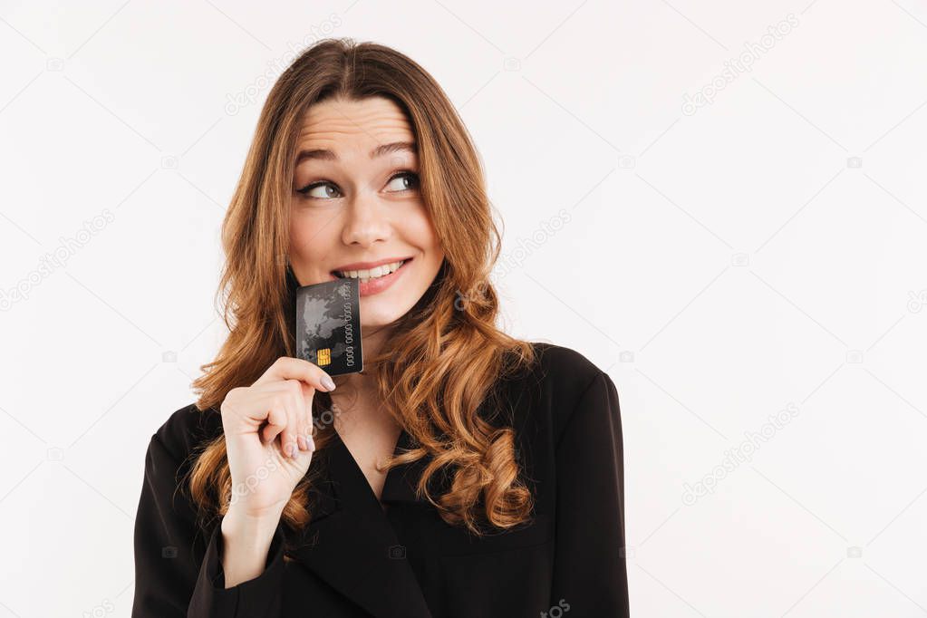 Pensive smiling elegant woman in coat holding credit card