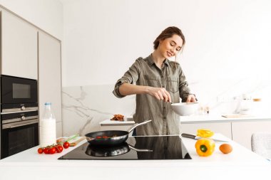 Güzel ev kadını taze v kullanarak lezzetli yemek pişirme portresi
