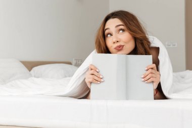 Beyaz battaniye altında yatakta istirahat romantik kadın portresi