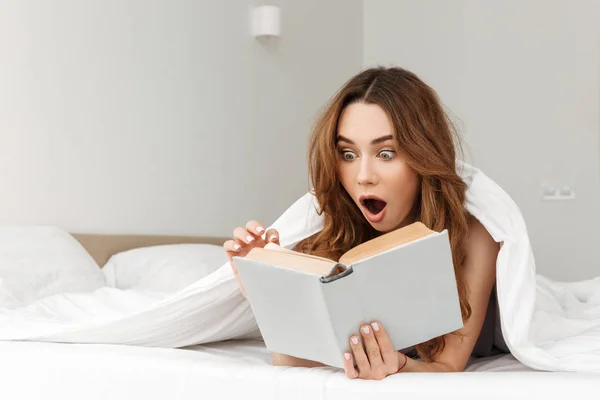 Portret van geschokt vrouw liggend in bed onder witte deken in worden — Stockfoto