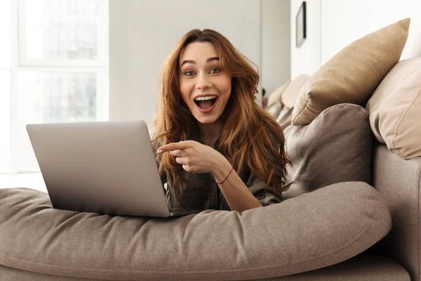 Image of happy european woman lying on sofa in living room, and — Stock Photo, Image