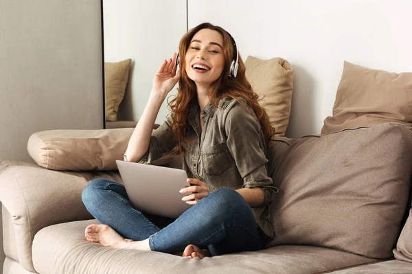 Bild einer zufriedenen Frau mit braunen Haaren, die Musik hört — Stockfoto