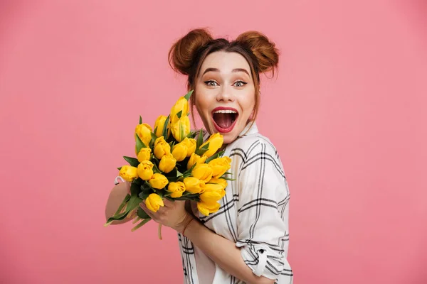 Retrato de uma jovem excitada segurando tulipas amarelas — Fotografia de Stock