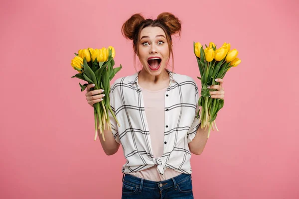 Retrato de uma jovem excitada segurando tulipas amarelas — Fotografia de Stock