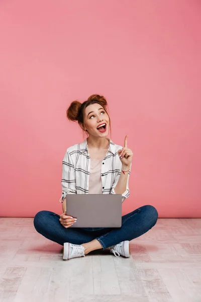 Retrato de una joven excitada sosteniendo el ordenador portátil —  Fotos de Stock